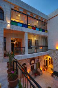 un edificio con balcón con sillas y mesas en Şems Inn, en Mardin
