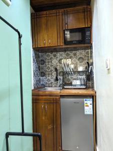 a small kitchen with a sink and a microwave at Chambre meublée cosy à Yaoundé in Yaoundé