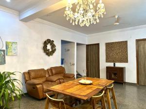 een woonkamer met een tafel en een bank bij 3 BHK entire villa near Medanta hospital in Gurgaon