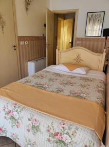 ein Schlafzimmer mit einem großen Bett mit einer Blumenbettdecke in der Unterkunft D'Elite Room & Breakfast in Ferrara