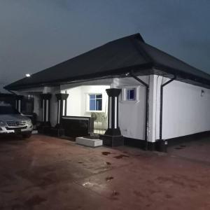 un grande garage bianco con tetto nero di Biji Paradise Hotel a Benin City