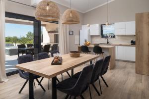 cocina y comedor con mesa de madera y sillas en Villa Mareta, en Ljubač