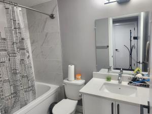 La salle de bains est pourvue de toilettes, d'un lavabo et d'une baignoire. dans l'établissement Cozy Basement Suite - private entrance - Free Netflix, à Edmonton