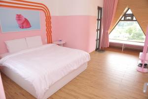 a bedroom with a white bed with a painting of a cat at AN PHÚ Home in Da Lat