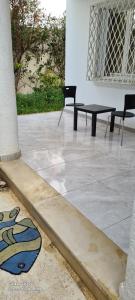 patio z 2 krzesłami i stołem w obiekcie duplex avec jardin w mieście Dar el Haj Ahmed Souid
