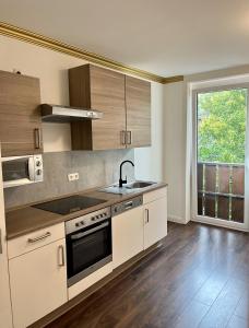 a kitchen with white cabinets and a sink and a window at STADtPERLE in Itzehoe