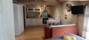 ein Wohnzimmer mit einem Tisch und einer Küche in der Unterkunft Studio Du Cluzel in Pontcirq