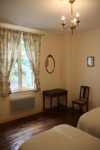 a bedroom with a window and a table and a chair at La maison de Léonard, Aux grilles du Château de Saint-Aignan, à 2km de Beauval in Saint-Aignan