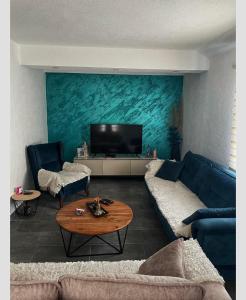 a living room with a blue couch and a flat screen tv at Studios Merdović in Budva