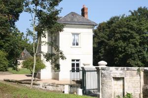 an old white house with a stone fence at La maison de Léonard, Aux grilles du Château de Saint-Aignan, à 2km de Beauval in Saint-Aignan