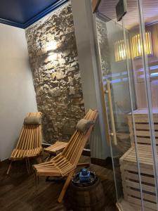 two chairs sitting in a room with a stone wall at Apartament Baron II ***** in Jelenia Góra