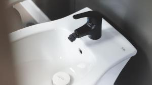 a white sink with a black faucet at ISOLA VERDE Camping Village in Nettuno