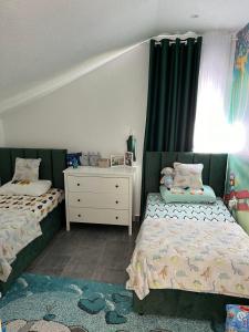 a bedroom with two beds and a dresser and a window at Studios Merdović in Budva