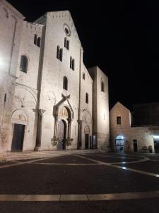 a large white building at night with a street at Bari in un click in Bari