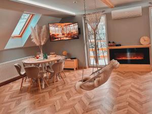 uma sala de estar com uma mesa e um baloiço em Apartament z sauną i jacuzzi na wyłączność - Sikorówka - Dobre Miejsce em Wisla