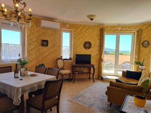 a living room with a table and chairs and a television at Francesca Apartmanlakása in Tapolca