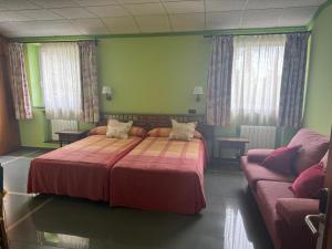 um quarto com uma cama grande e um sofá em Real Hotel em Guardo