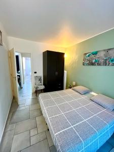 a bedroom with a bed and a black cabinet at appartement Breil sur Roya centre in Breil-sur-Roya