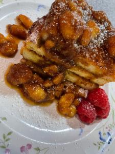 een witte plaat met een stuk cake en aardbeien bij Creole Dame Bed & Breakfast Inn in Sumter