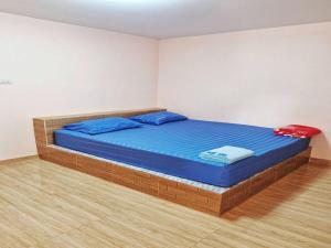 1 dormitorio con 1 cama con sábanas azules y almohadas azules en OYO 75488 Leelawadee View Resort (Amnatcharoen) en Amnat Charoen
