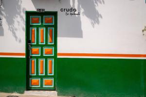 a green door with orange squares on the side of a building at Eco Apartamento Crudo in Jardin