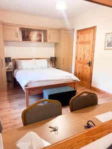 Kilcar的住宿－Kilcar Lodge，卧室配有一张床和一张桌子及椅子
