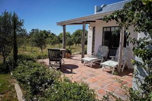 un patio con 2 sillas y una mesa frente a una casa en Boerfontein, en Windmeul