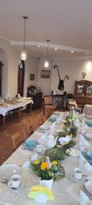 een lange tafel met borden en kommen en bloemen erop bij Gościnny Dom in Ustroń