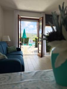 a living room with a blue couch and a sliding glass door at Aviotel Residence in Marina di Campo