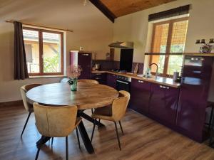een keuken met een houten tafel en stoelen bij Les Vergers d'Epona "Fremifontaine VOSGES" in Frémifontaine