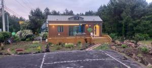 una pequeña casa en un patio con entrada en Hamdeok pool villa pension, en Jeju