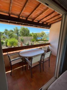 patio con mesa y sillas en el balcón en Résidence Le Golfe Bleu en Rayol-Canadel-sur-Mer
