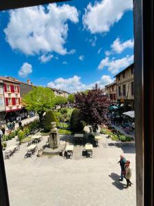 um grupo de pessoas em pé em um pátio com uma fonte em La Cite No 25 superbe apartment plein centre calme ,Netflixl em Mirepoix