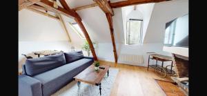 a living room with a blue couch and a table at Appartement Aéroport Orly in Athis-Mons