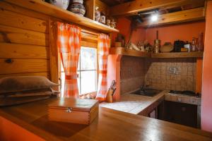 kuchnia z pomarańczowymi ścianami, oknem i blatem w obiekcie Chata JÚLIA w mieście Vernár