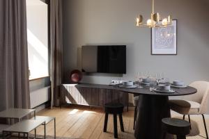 - un salon avec une table, des chaises et une télévision dans l'établissement Centra Nams - Center Apartments, à Cēsis