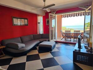 a living room with a couch and a checkered floor at Appartamento Vista Mare - Spriano in Rio Marina