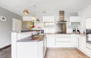 una cocina con armarios blancos y encimeras de mármol en Lovely Home In Saint-Georges-De-Didon, en Saint-Georges-de-Didonne