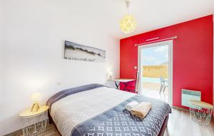 1 dormitorio con pared roja, cama y escritorio en Lovely Home In Saint-Georges-De-Didon, en Saint-Georges-de-Didonne