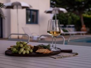 una copa de vino y un plato de comida en una mesa en Azzurro Holiday Villas, en Peyia