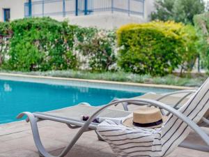a hat sitting on a chair next to a pool at Azzurro Holiday Villas in Peyia