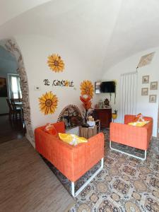 sala de estar con 2 sofás naranjas y chimenea en B&B Il Girasole, en Finale Ligure