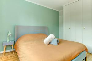 ein Schlafzimmer mit einem Bett mit einem Kissen darauf in der Unterkunft Villa Les Fleurs in Montigny-le-Bretonneux