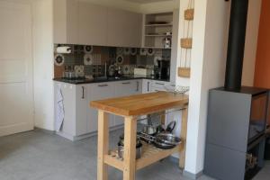 洛迦諾的住宿－La Pineta，厨房配有白色橱柜和木桌