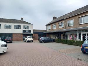 a parking lot with cars parked in front of buildings at Penthouse centrum Krabbendijke in Krabbendijke
