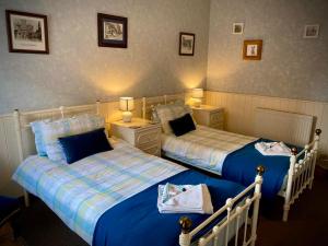 duas camas num quarto ao lado um do outro em The George and Dragon Inn em Knighton