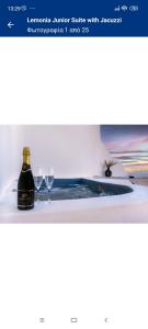 a bottle of wine and two wine glasses on a table at LEMONIA STUDIOS&SUITES in Agia Anna Naxos