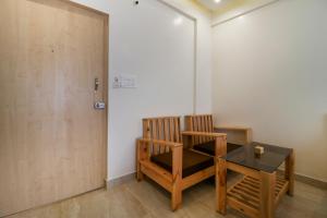 um quarto com uma mesa, uma cadeira e uma porta em Collection O Prime Residency em Bangalore