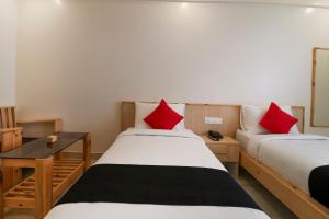 Duas camas num quarto com almofadas vermelhas em Collection O Prime Residency em Bangalore