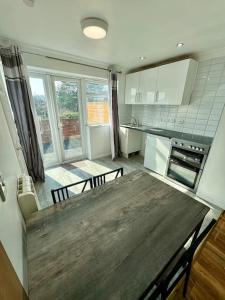 eine Küche mit Holztisch und ein Esszimmer in der Unterkunft Flat on high street in Saltdean